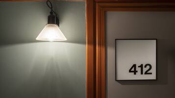Een kamer met een wandlamp en een bord met het nummer 412.