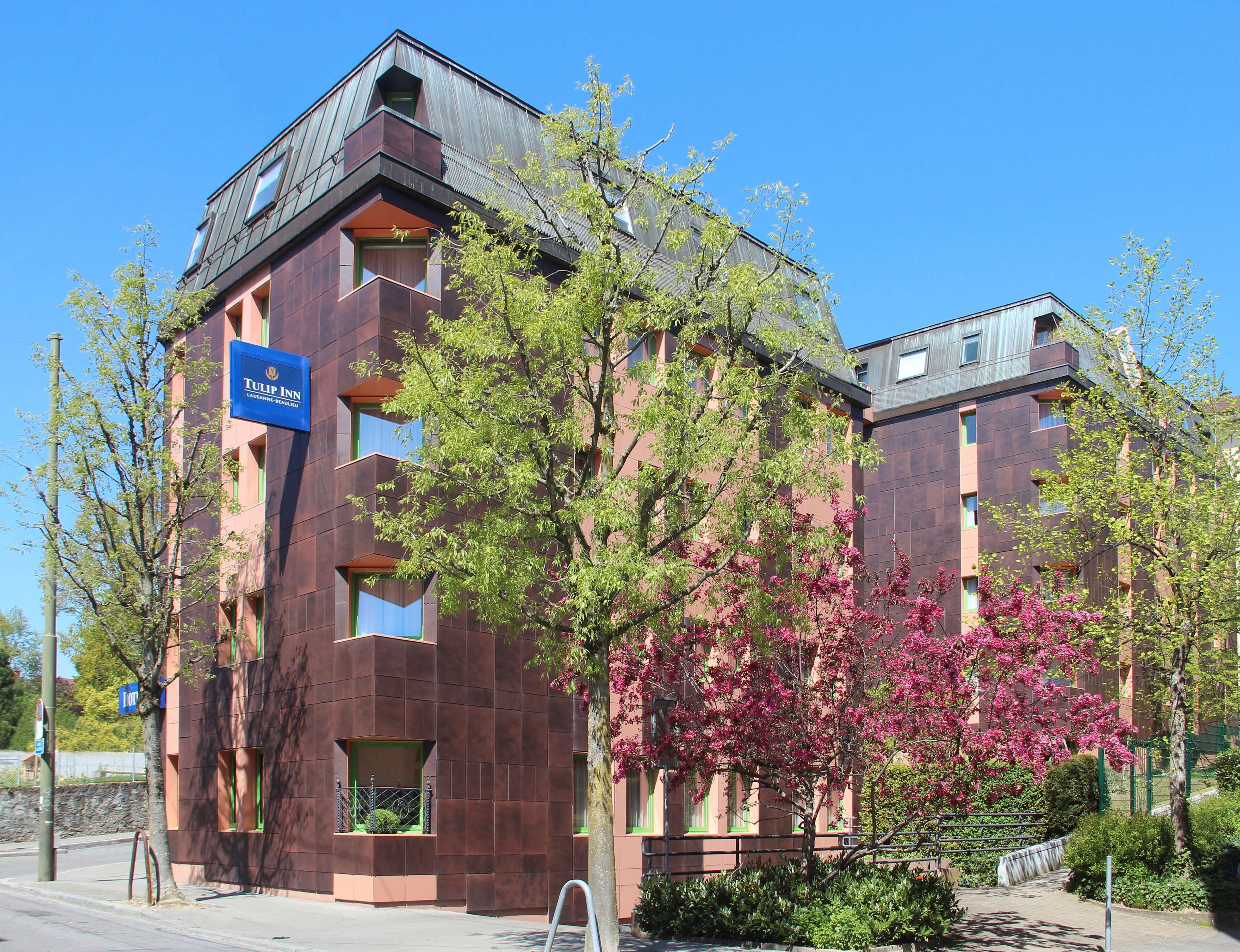 A modern hotel building with a sign reading "Tulip Inn."