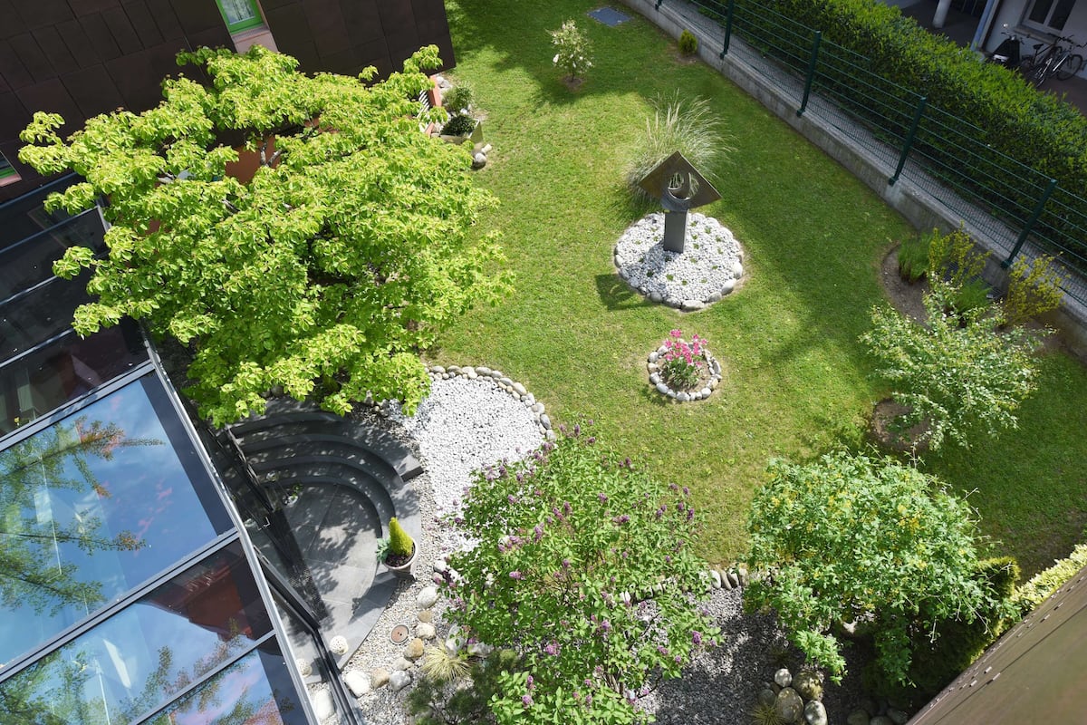Ein angelegter Garten mit verschiedenen Pflanzen und einem zentralen Ziertelement.