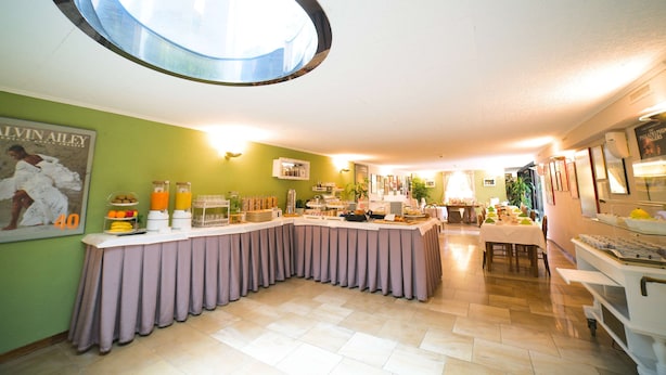 A breakfast buffet with a variety of food items and a large circular skylight. - Tulip Inn Lausanne Beaulieu (Lausanne)