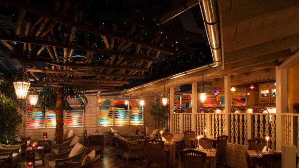 A restaurant with wicker furniture, hanging lights, and a wooden ceiling. - Boutiquehotel Thessoni Classic Zürich (Regensdorf)