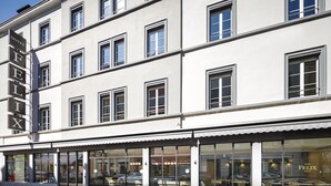 Un hôtel doté d’une façade moderne, de grandes fenêtres et d’un espace restaurant bien visible.