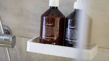 Two bottles of shampoo in a white, textured container.