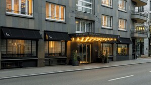 Een modern hotelgevel met grote ramen en een goed verlichte entree.