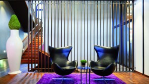 A modern interior with two black chairs, a white vase, and a purple patterned rug. - Sorell Boutique-Hotel Zürichberg (Zürich)