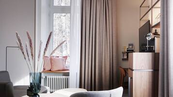 A modern room with a wooden desk, a chair, a radiator, a window with curtains, and a bookshelf.