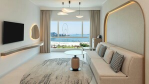 A modern hotel room with a large window offering a view of the beach and a Ferris wheel.