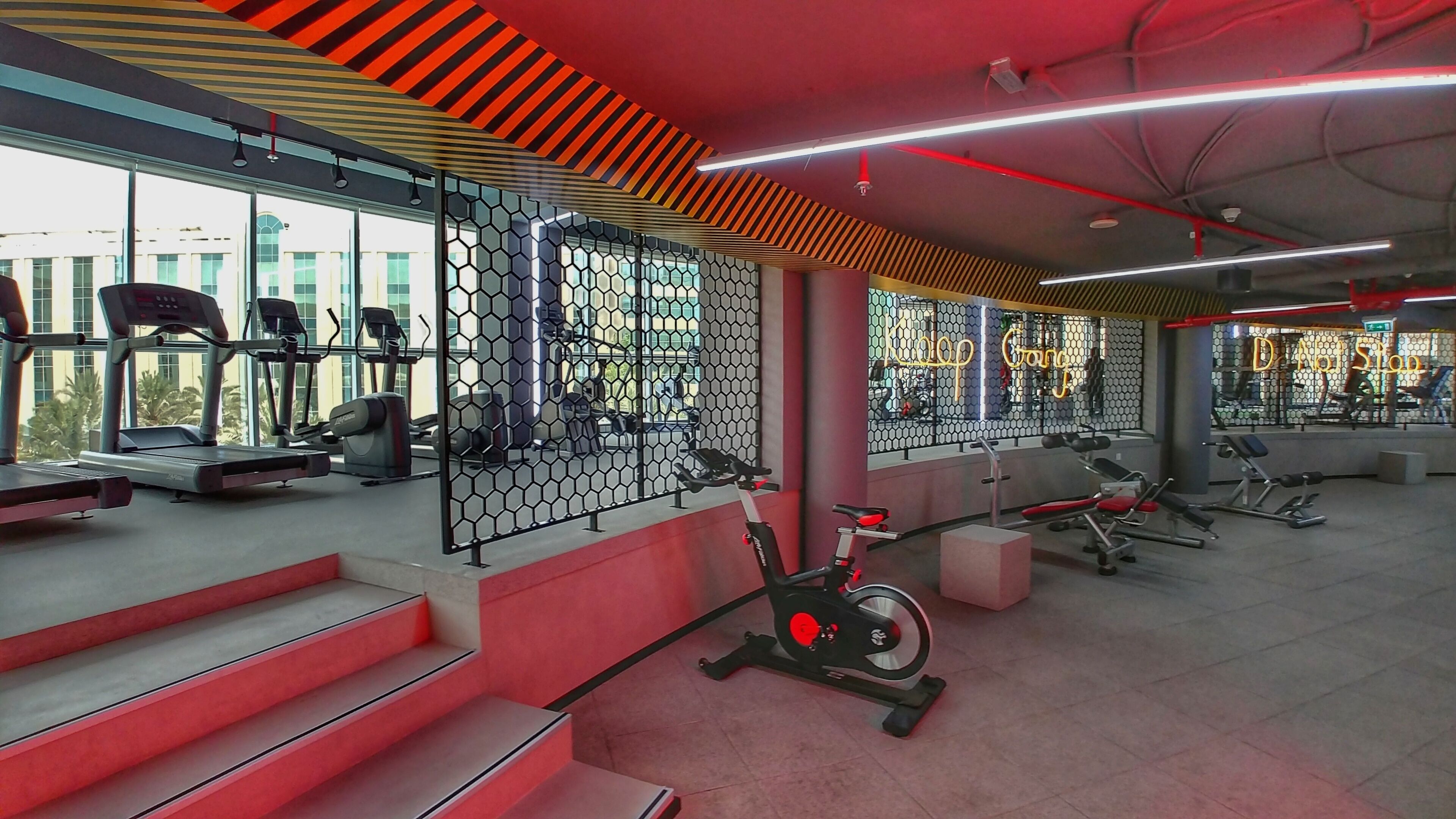 Un gimnasio con cintas de correr, bicicletas estáticas y máquinas de pesas.