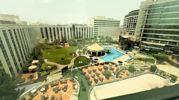 A hotel with a swimming pool, outdoor seating, and a well-maintained garden.