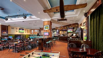 Eine Bar mit einer Fußballtischkickeranlage, Sitzgelegenheiten und einer Bar.