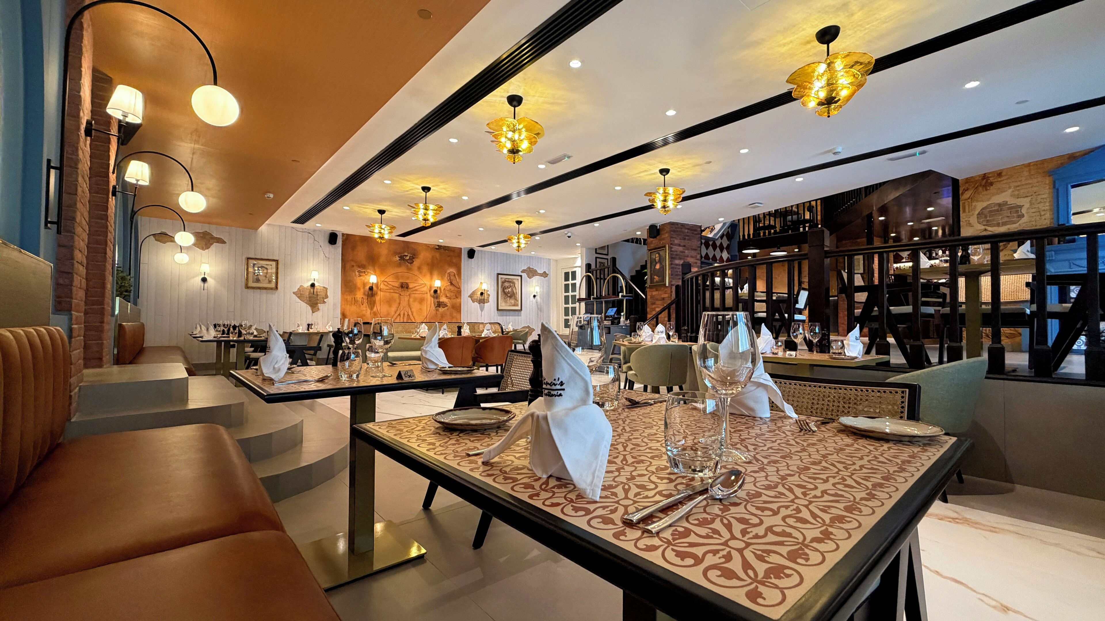 Un interno ristorante moderno con soffitti alti, pareti in mattoni a vista e lampade dal design contemporaneo.