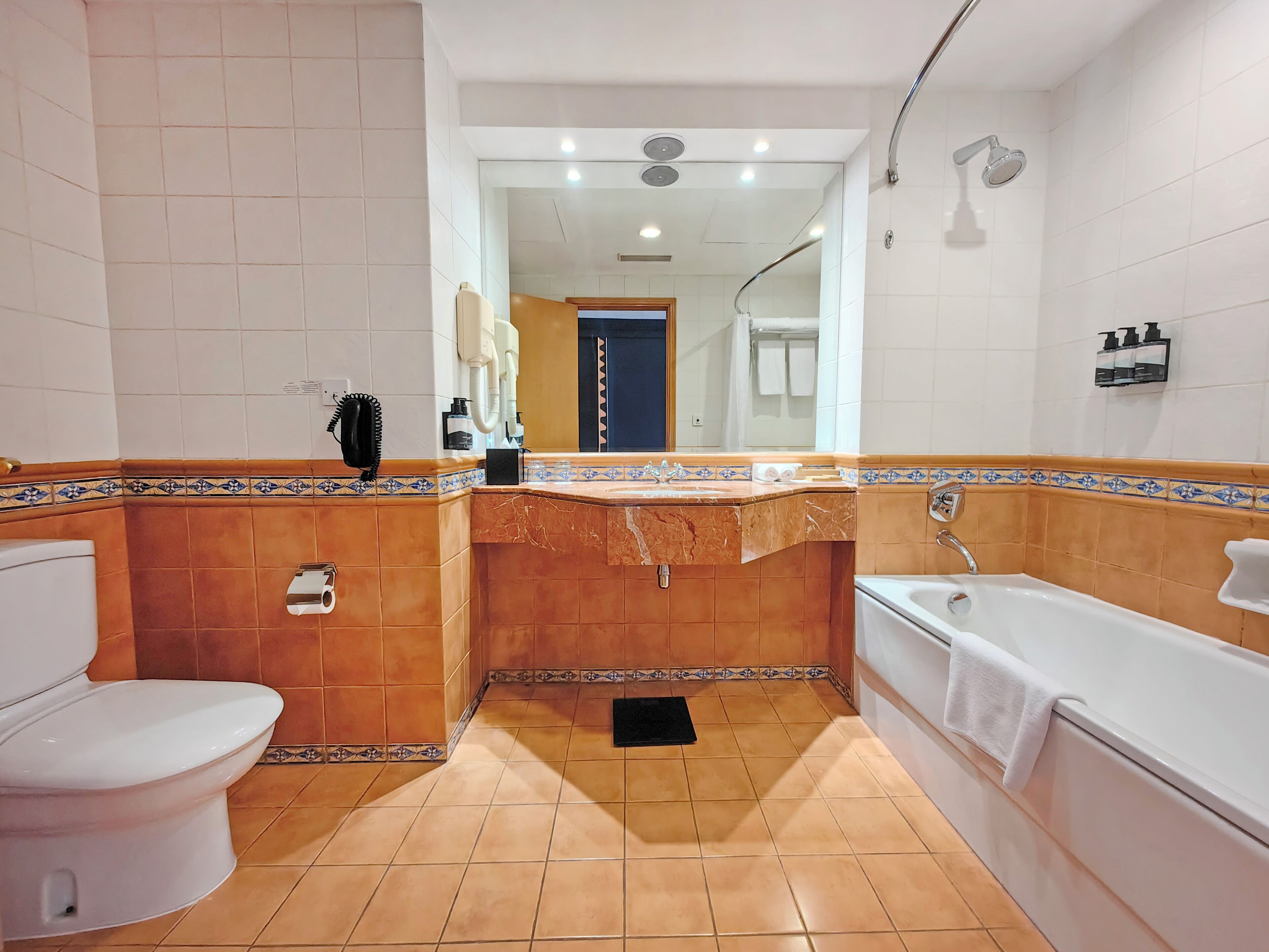 A bathroom with a white toilet, a bathtub, and a shower.