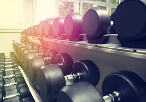 Une rangée d’haltères sur un support dans une salle de sport.