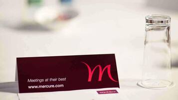 Cartão de visita com o texto 'Reuniões no seu melhor' e o endereço do site www.mercure.com.