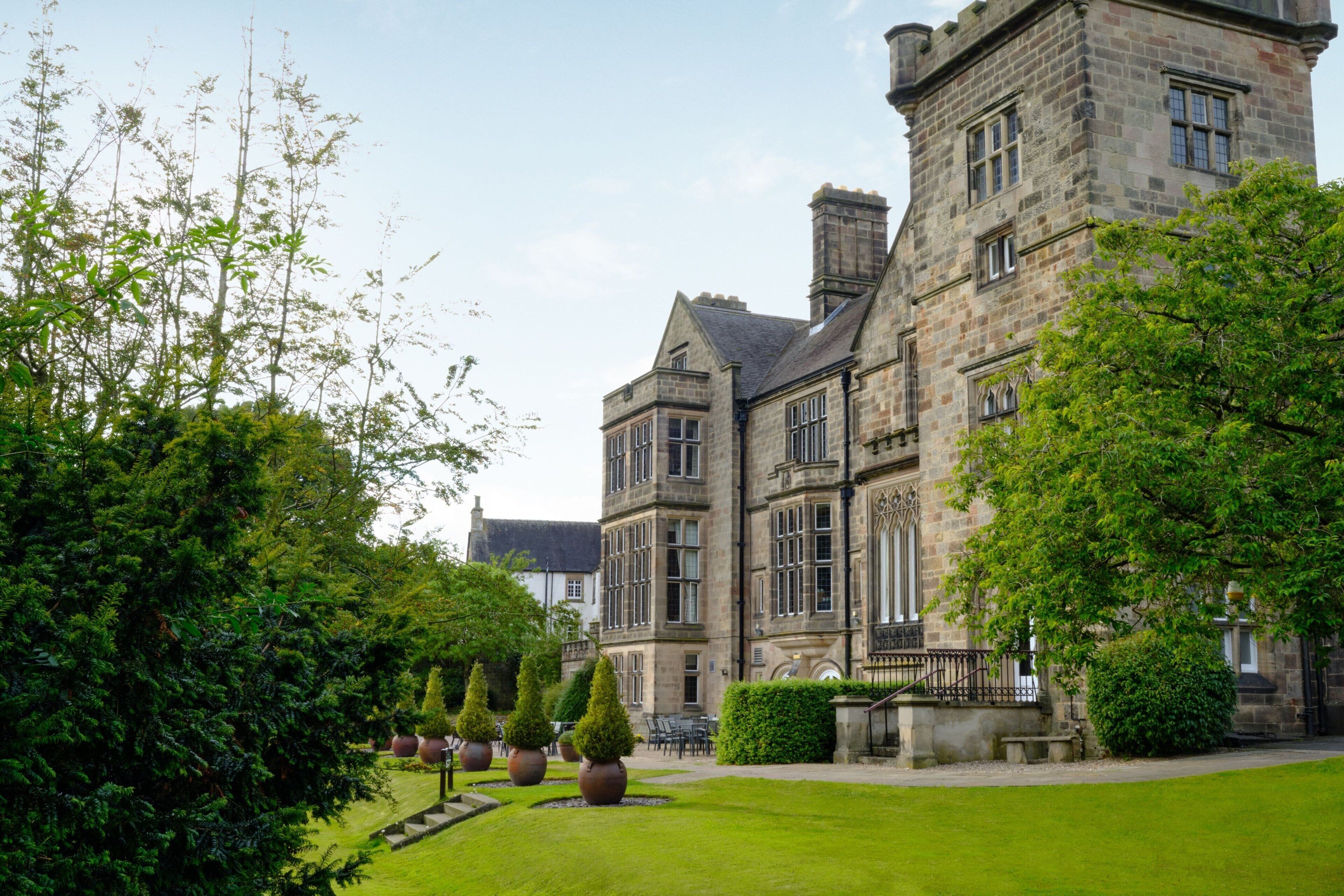 A large stone building with multiple windows and a well-maintained lawn.