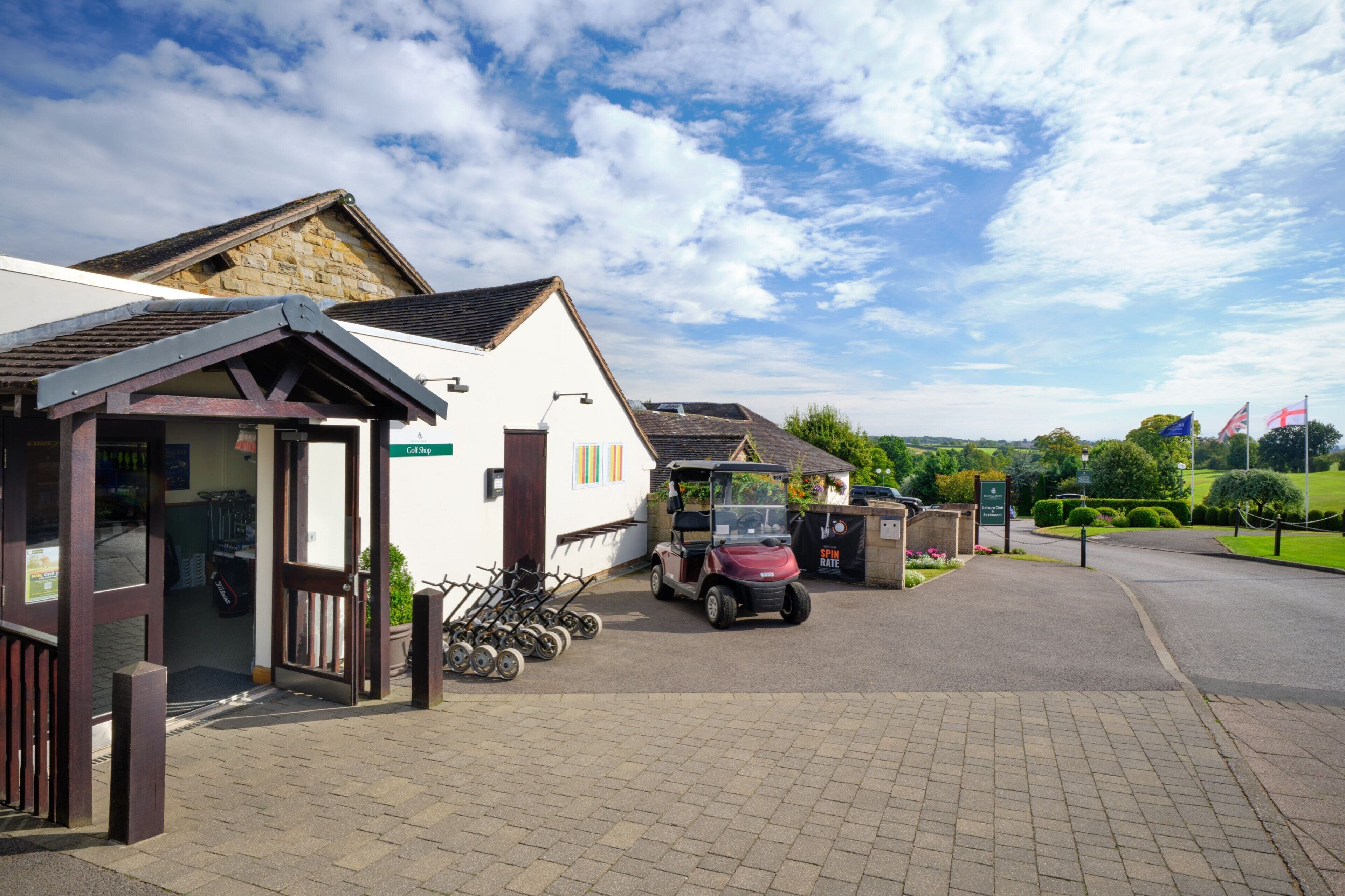 A building with a white facade, a covered entrance, and a golf cart parked outside.