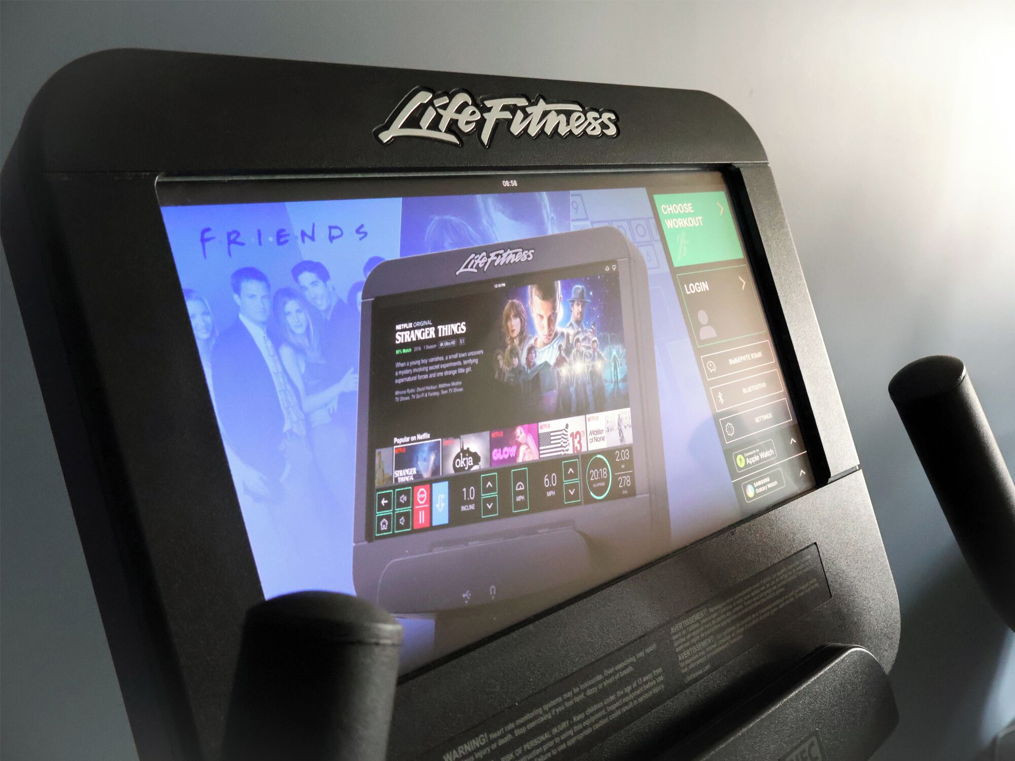Un vélo d’exercice de la marque Life Fitness doté d’un écran diffusant une émission de Netflix.