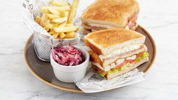 A plate with a sandwich, fries, and coleslaw.
