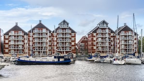 A waterfront building with multiple balconies and a marina with boats. - Holiday Inn Ipswich Orwell by IHG (Ipswich)
