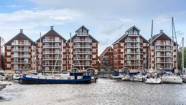 A waterfront building with multiple balconies and a marina with boats. - Holiday Inn Ipswich Orwell by IHG (Ipswich)