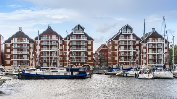 A waterfront building with multiple balconies and a marina with boats. - Holiday Inn Ipswich Orwell by IHG (Ipswich)