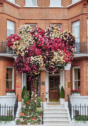A building with a brick facade, a wooden front door, and a balcony with black railings. - The Egerton House Hotel (London)