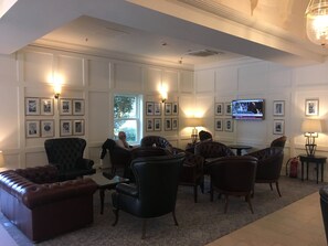 A spacious living room with a fireplace, comfortable seating, and a television mounted on the wall.