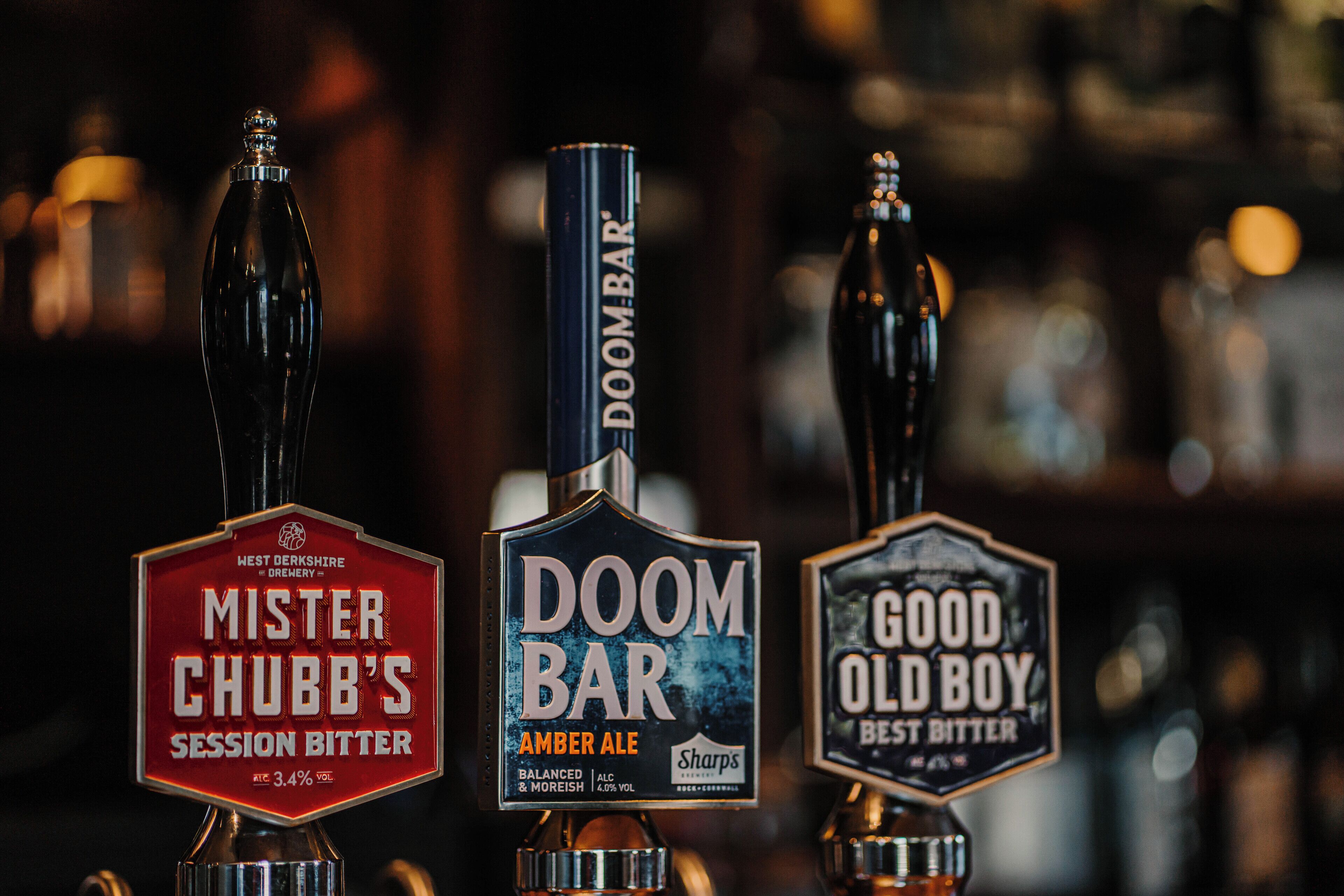 Trois robinets à bière portant les noms suivants : « Mister Chubb's Session Bitter », « Doom Bar Amber Ale » et « Good Old Boy Best Bitter ».