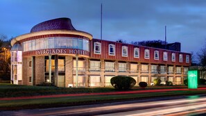 Ein Hotel mit einer geschwungenen Fassade, zahlreichen Fenstern und einer markanten Schilderung.
