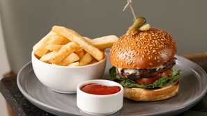 Ein Teller mit einem Burger, Pommes und Ketchup.