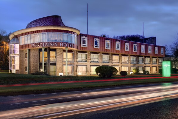 Das Everglades Hotel mit einer geschwungenen Fassade, großen Fenstern und einem markanten Eingang.