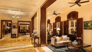 A spacious lobby with a marble floor, a sofa, a coffee table, and a ceiling fan. - Sofitel Legend Metropole Hanoi (Hanoi)