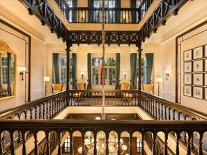 A grand staircase with ornate railings, multiple levels, and a chandelier. - Sofitel Legend Metropole Hanoi (Hanoi)