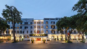 A grand hotel with a central entrance, multiple floors, and a well-lit facade. - Sofitel Legend Metropole Hanoi (Hanoi)
