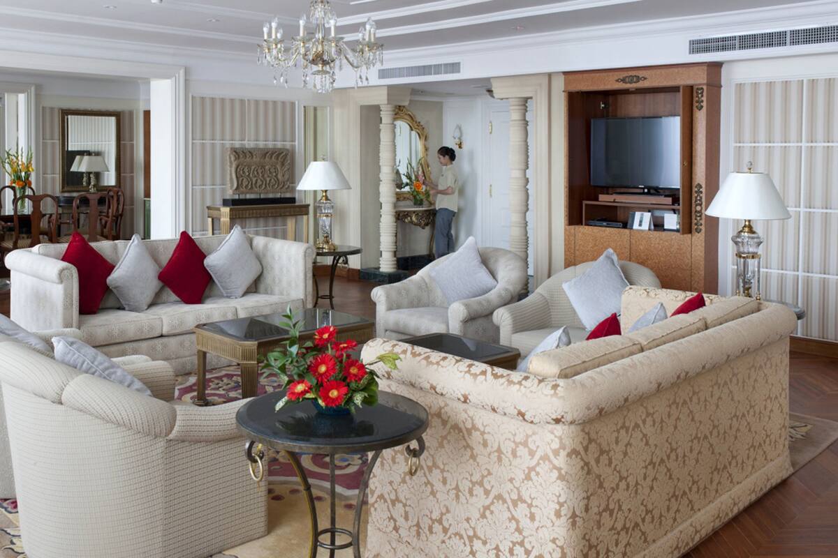 A spacious living room with a large sofa set, a coffee table, and a television.