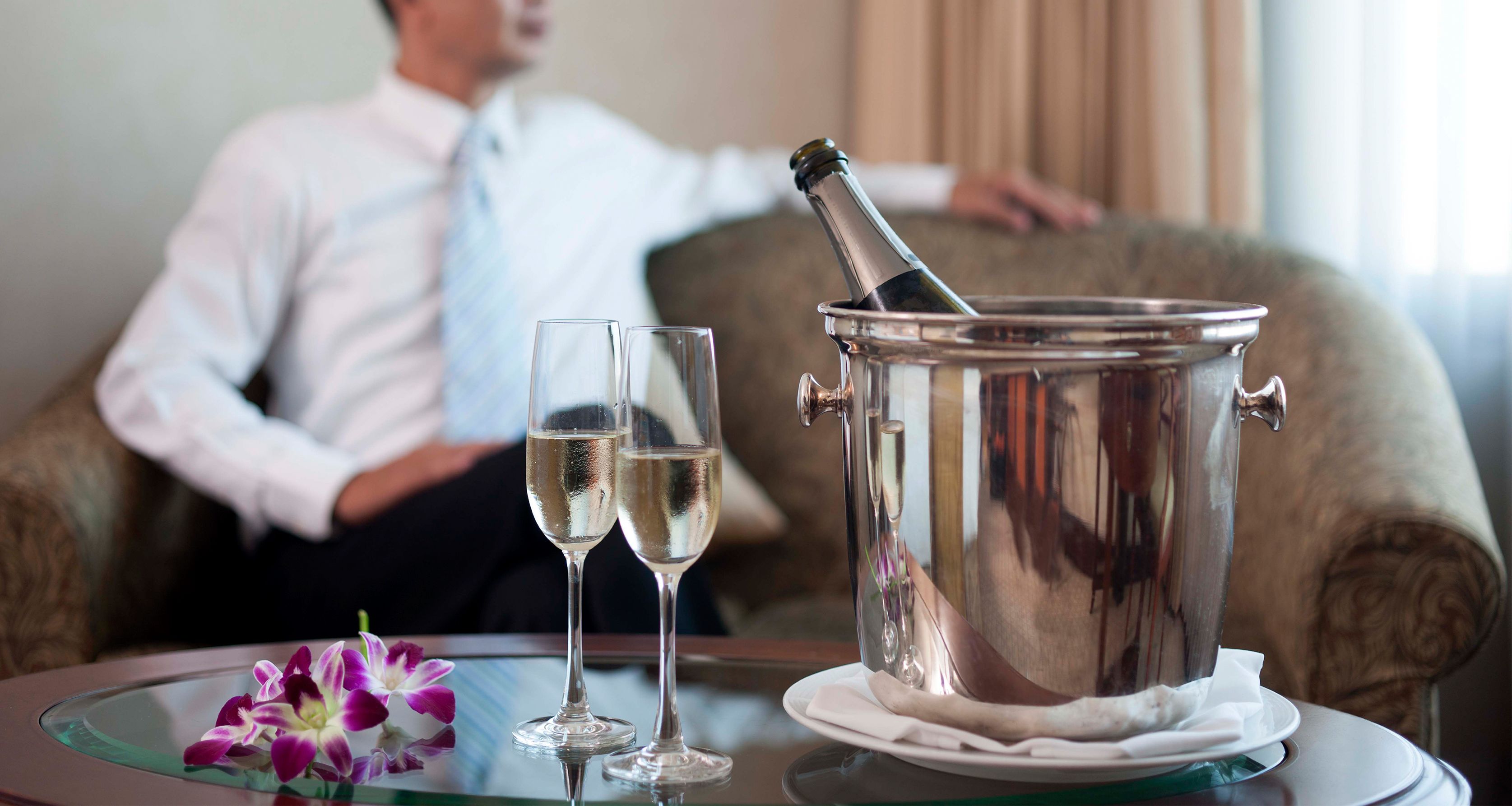 A table with two champagne flutes and a champagne bottle in a metal bucket.