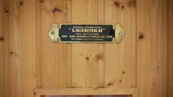 A wooden wall with a metal plaque that reads "Original Finnish Sauna Lagerholm Sole Distributor."