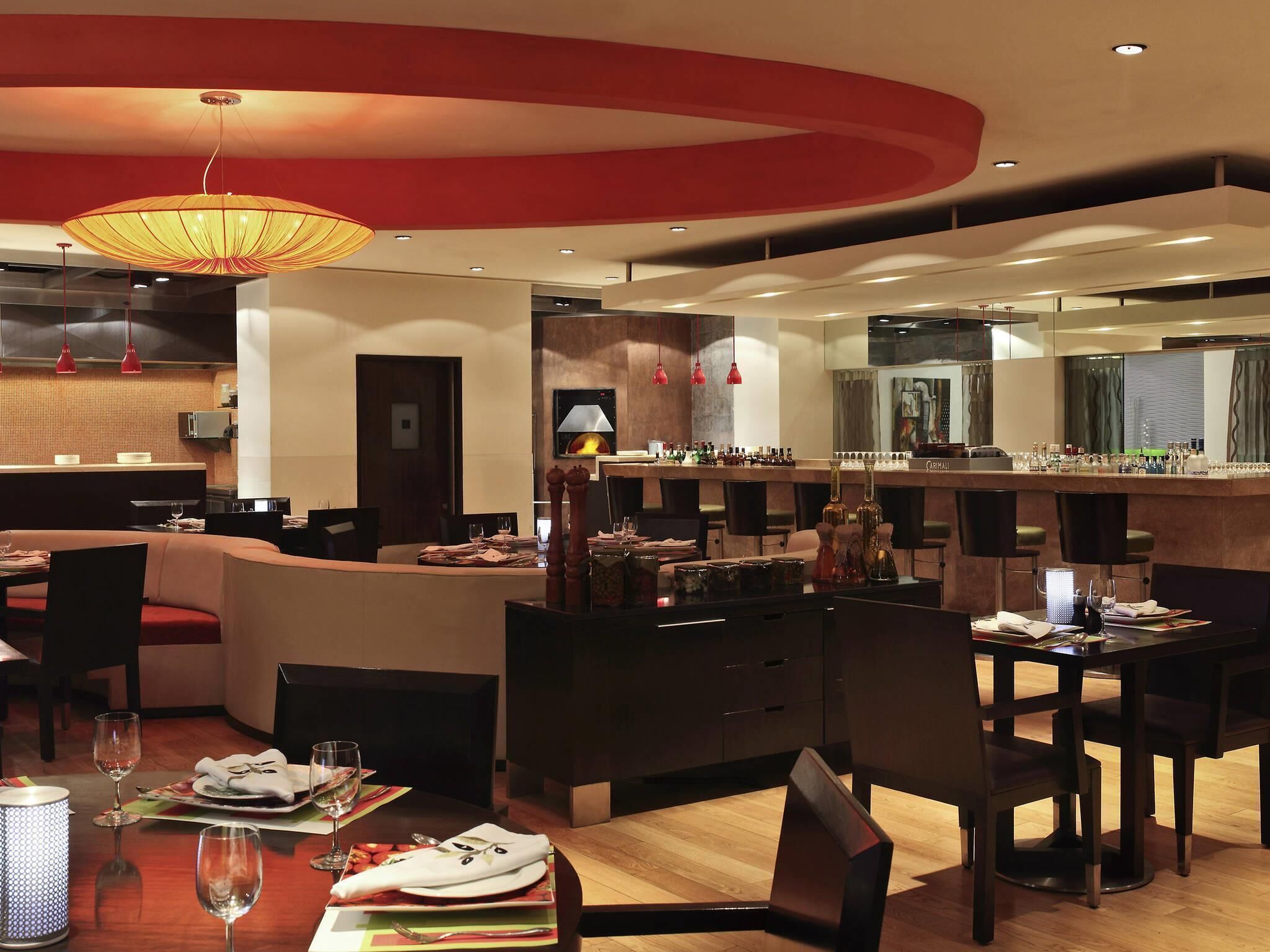 A modern hotel lobby with a bar area, seating arrangements, and a fireplace.