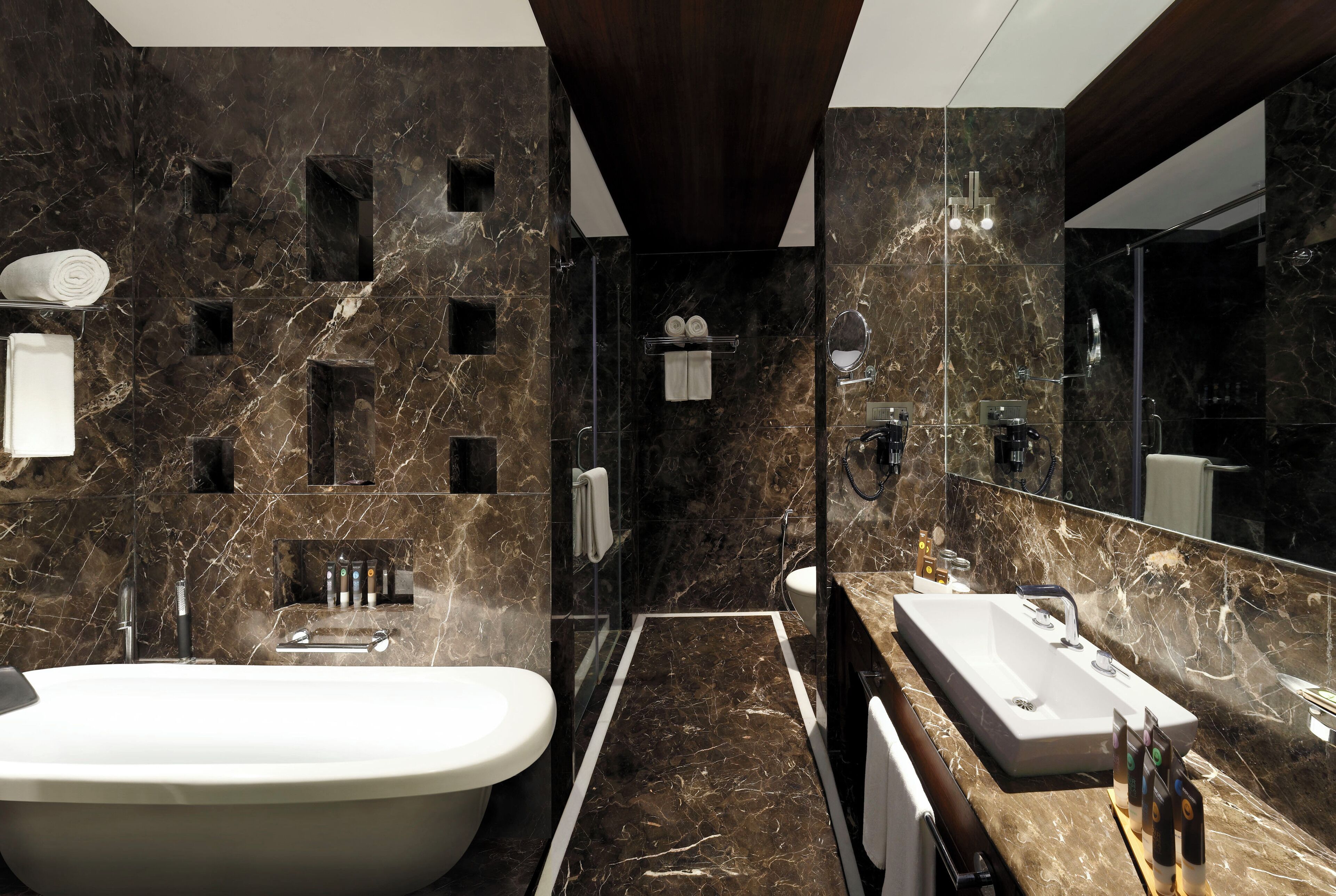 Un baño moderno con una bañera independiente, un tocador espacioso con lavabo y un espejo.