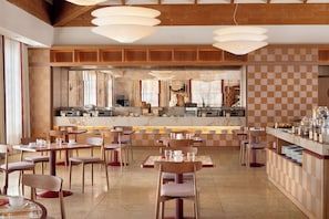 A modern restaurant interior with wooden paneling, marble countertops, and a central dining area with tables and chairs. - Sheraton Rome Parco de’ Medici (Rome)