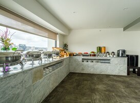 Cocina moderna con encimeras de mármol, cafetera y vistas a la ciudad.
