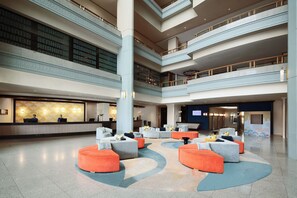 Relax in our spacious lobby, featuring a central seating area and polished floors.