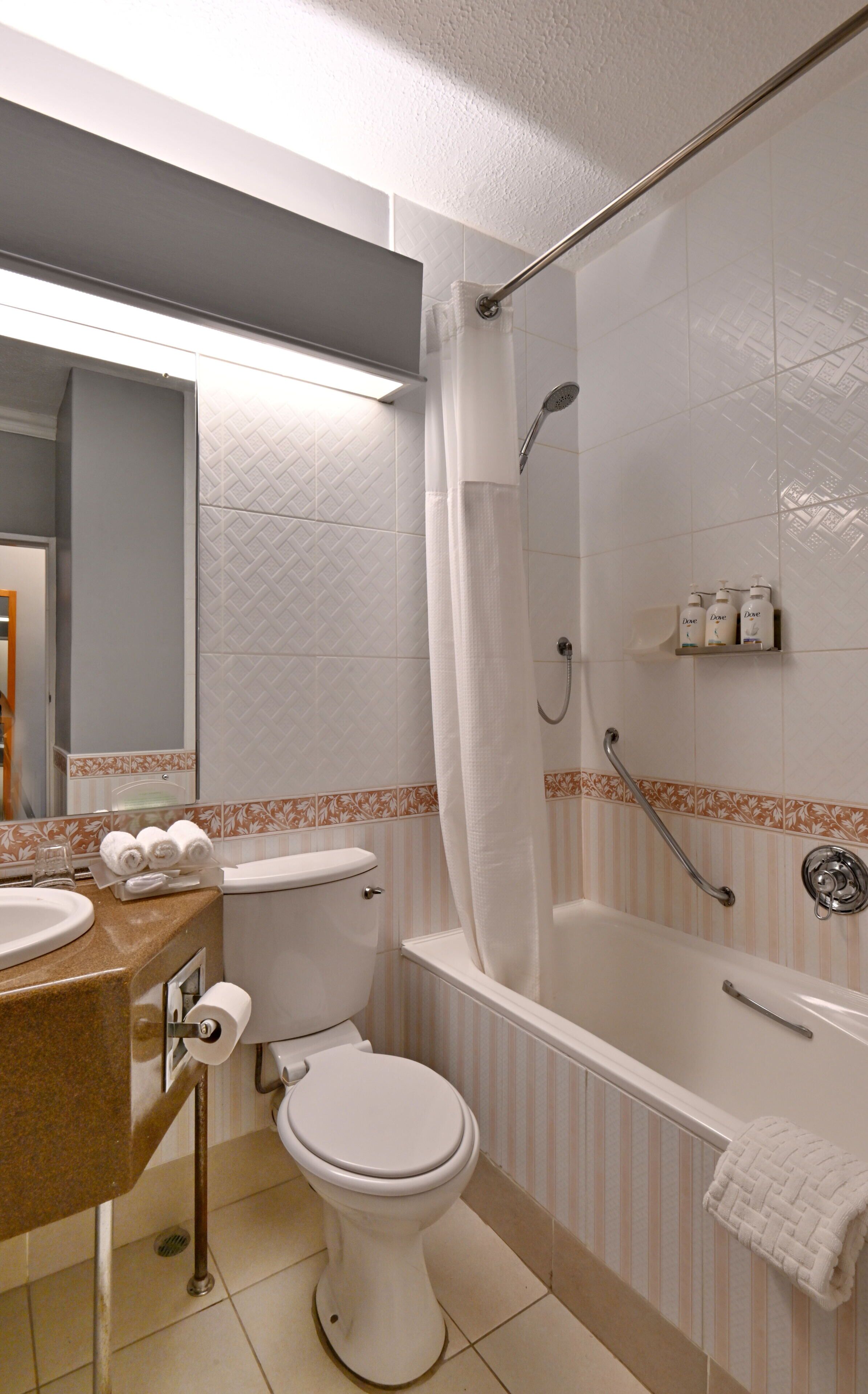 A bathroom with a toilet, sink, and bathtub.