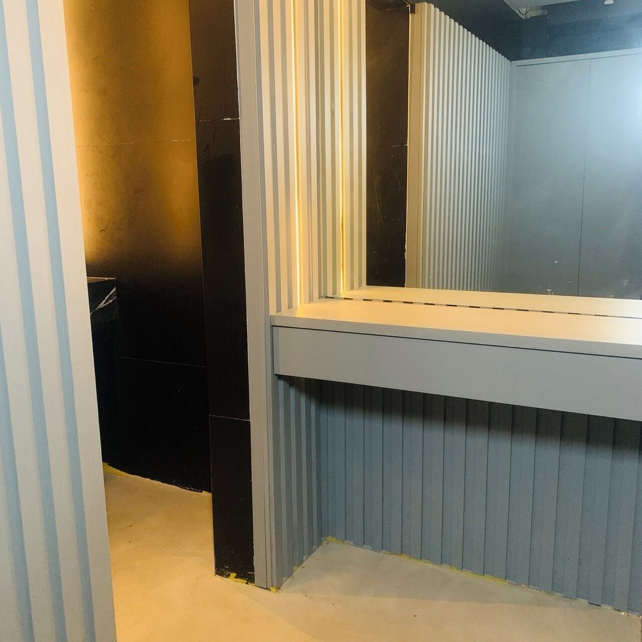 A bathroom with a mirror, a sink, and a toilet.