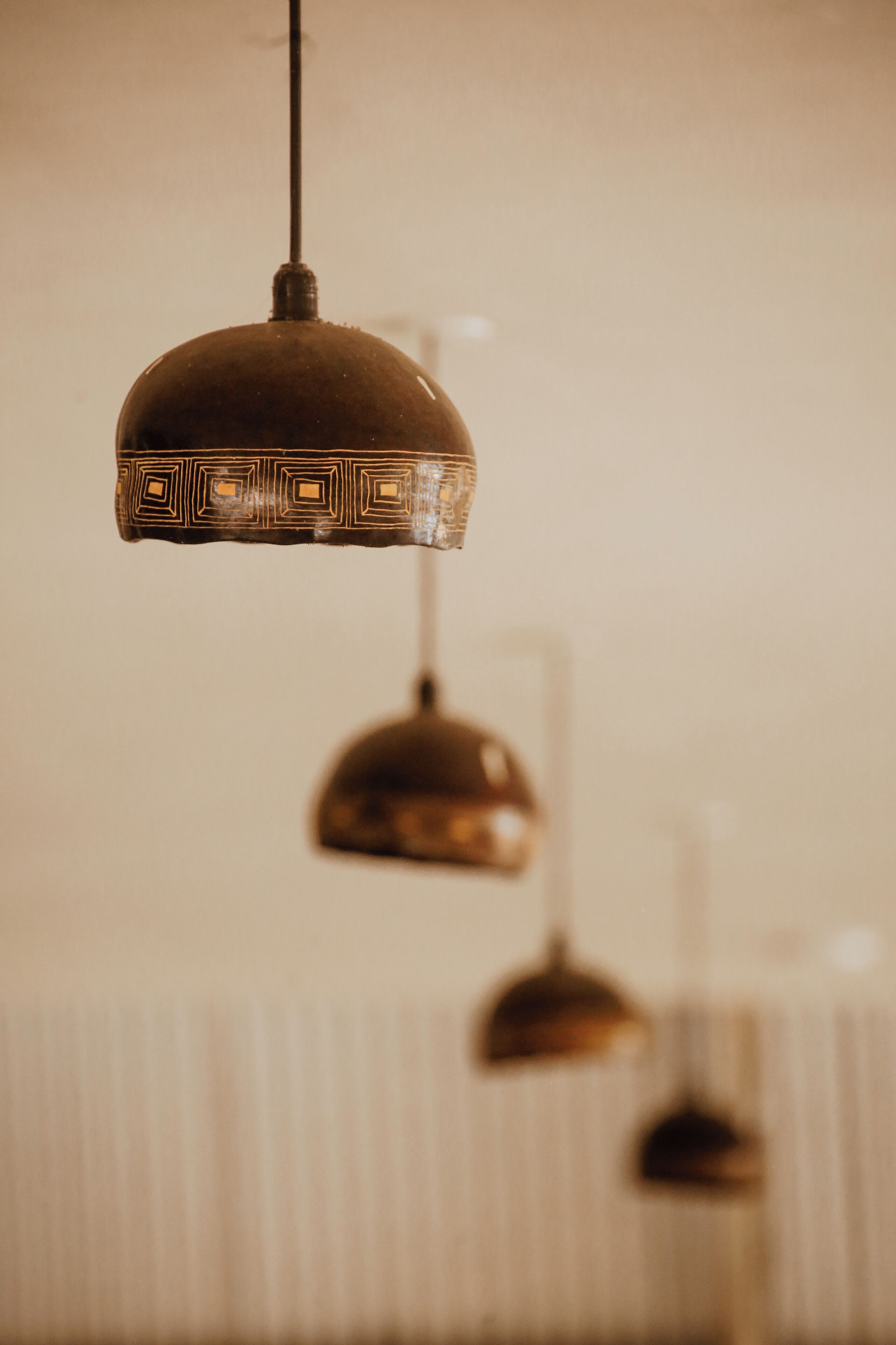 A hanging pendant light fixture with a geometric pattern.