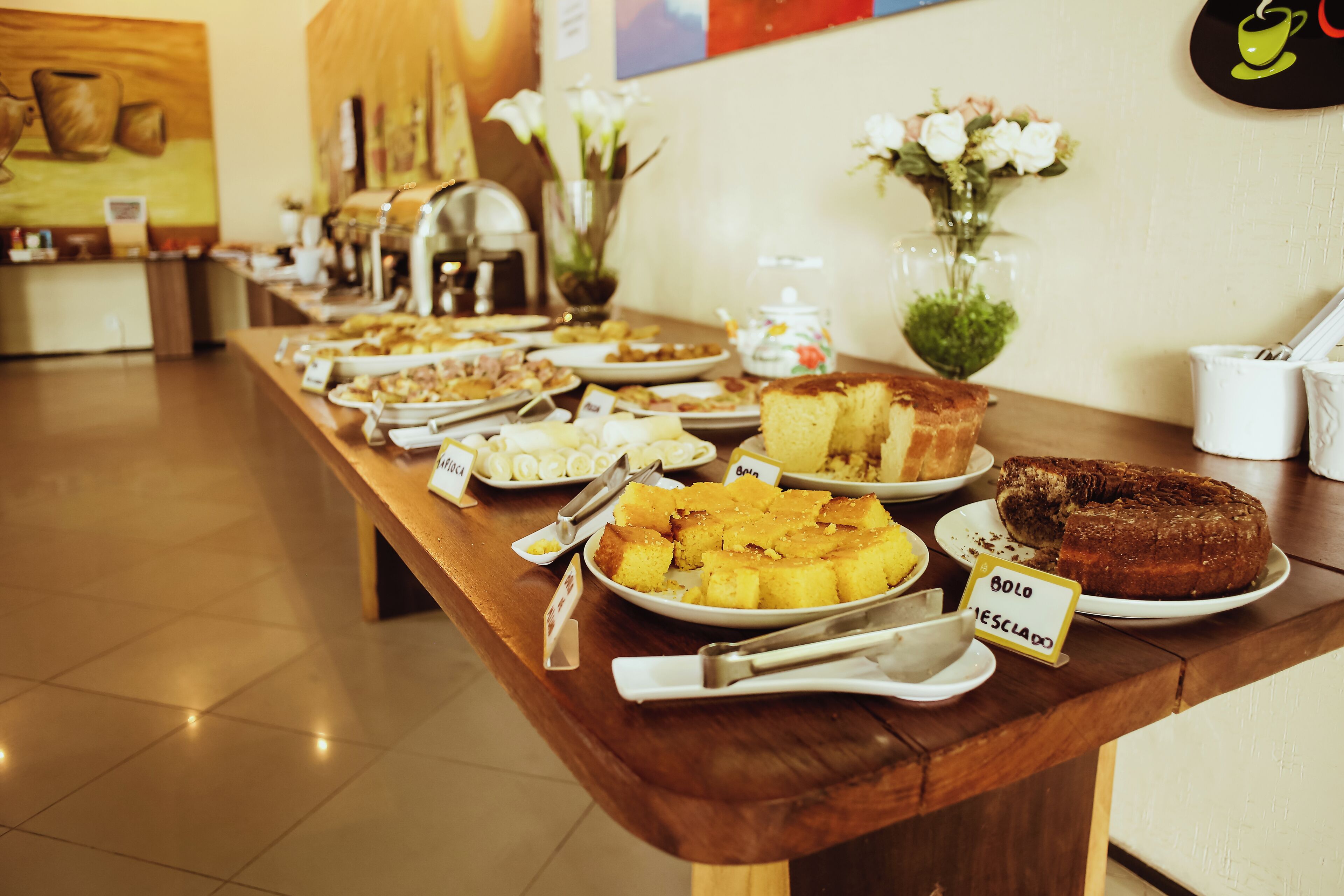 Una mesa de buffet con diversos platos y un letrero que indica 'Bolo' y 'Esclado'.