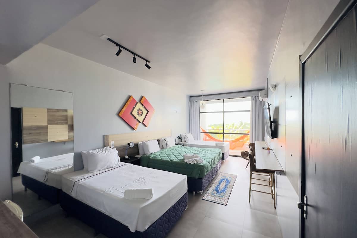 A modern hotel room with two beds, a large window with a view, a ceiling light, and a wall-mounted TV.