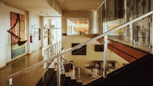 A spacious interior with a staircase, a dining area, and artwork on the walls. - Barrudada Tropical Hotel (Santarém)