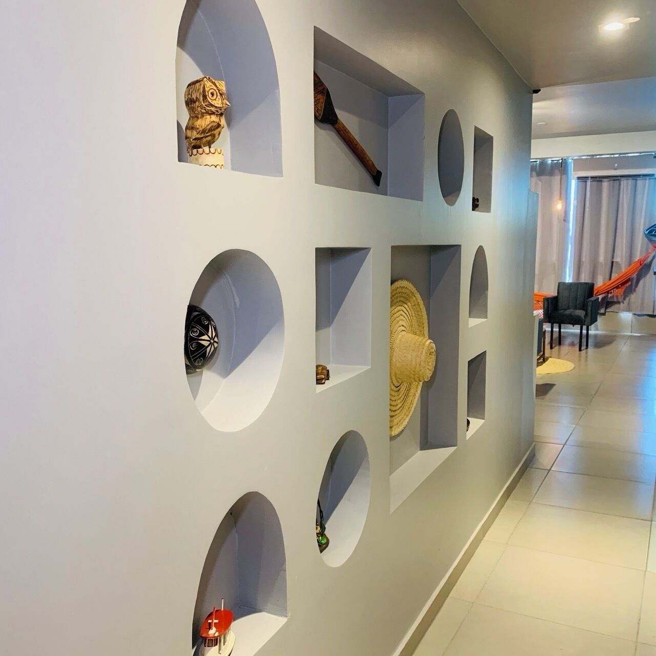 A hallway with circular cutouts displaying various items.