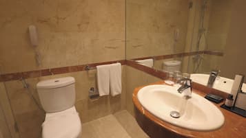 Un baño con inodoro, lavamanos y ducha.